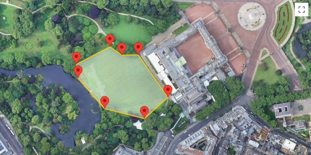 Aerial satellite view of a green rectangular field outlined in yellow, with eight red location pins marking points around the perimeter, situated between trees, a lake, and a large historic building.