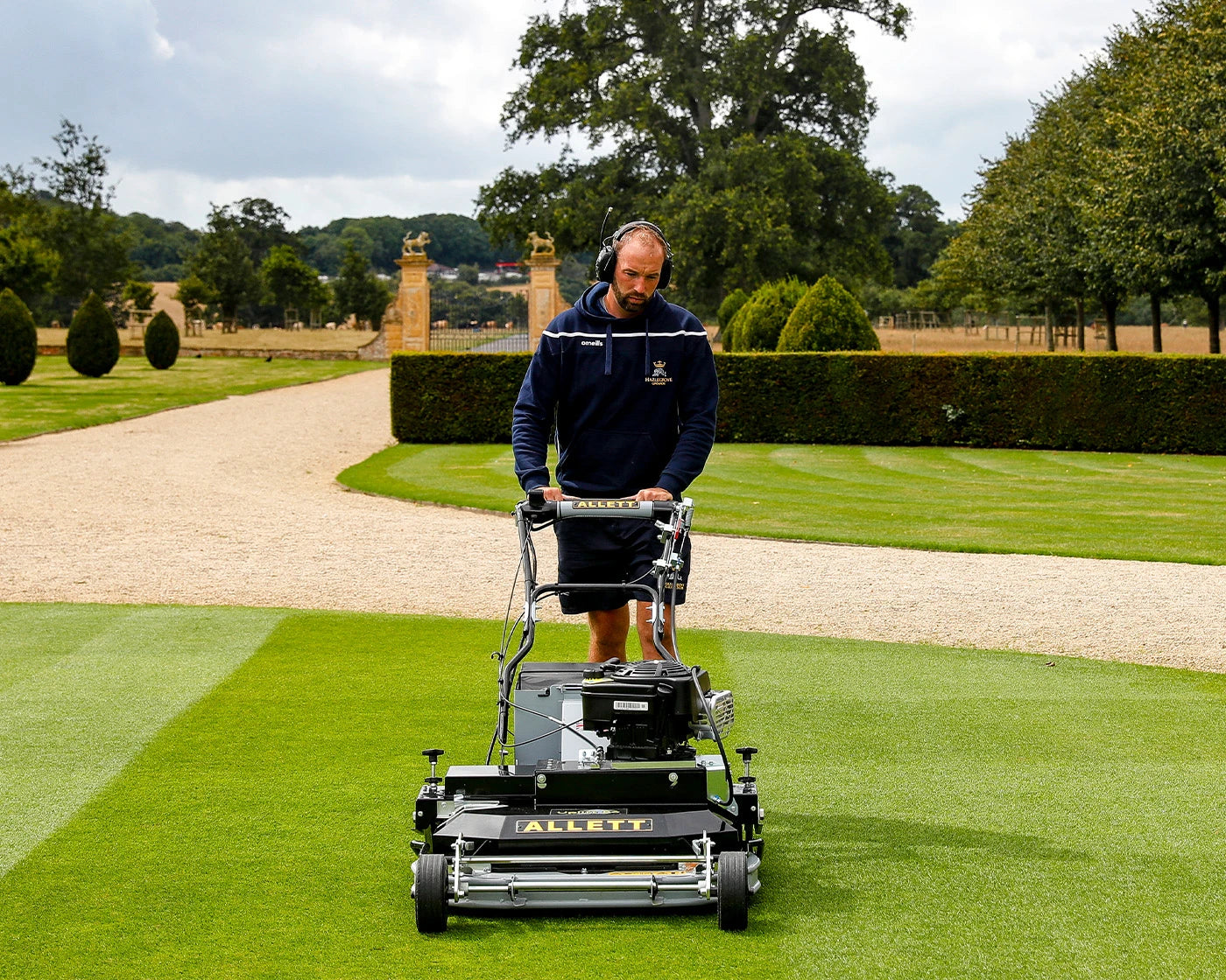 Allett Uplift 86 vacuum rotary mower collecting debris in a park